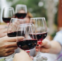people tossing their clear wine glasses