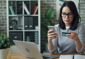 a woman sitting at a table looking at her cell phone